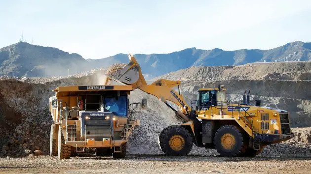Picture description: A wheel loader operator fills a truck with ore at the MP Materials rare earth mine in Mountain Pass, California